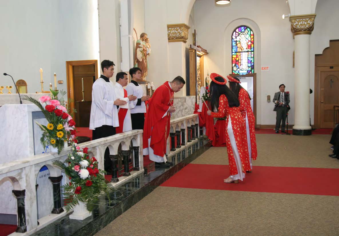 Young women carrying incense bow before Fr. Francis.